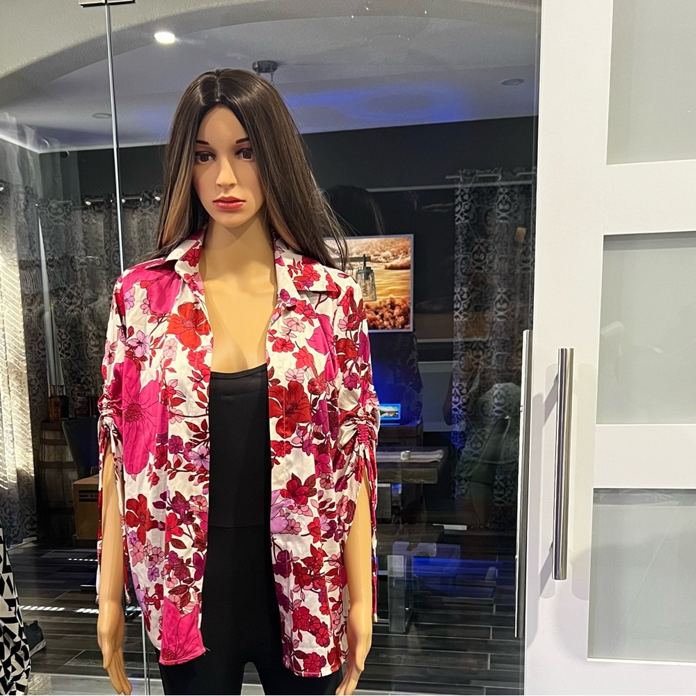 Blouse printed with red and pink fuchsia flowers , the fabric is satin
